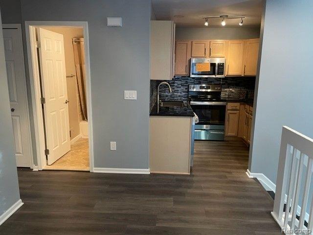 1530 Maryland Club Dr, Royal Oak, MI 48067 - kitchen with appliances with stainless steel finishes, dark countertops, dark wood-style flooring, and backsplash