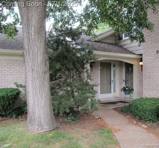 2667 Williamsburg Cir, Auburn Hills, MI 48326 - doorway to property featuring brick siding and a shingled roof
