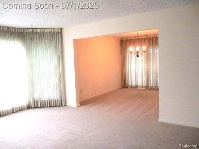 2667 Williamsburg Cir, Auburn Hills, MI 48326 - carpeted empty room with a chandelier and a textured ceiling