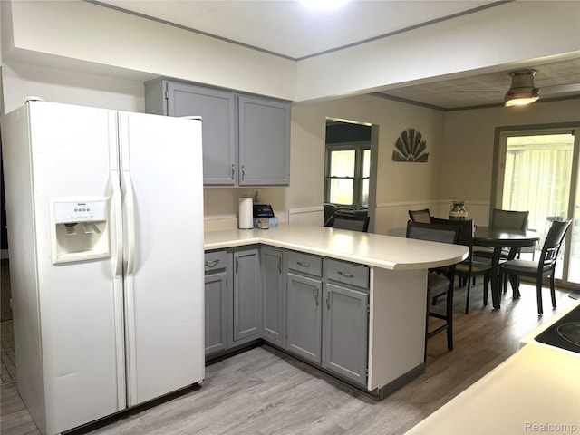 25830 Matilda Ave, Trenton, MI 48134 - kitchen featuring white fridge with ice dispenser, gray cabinetry, a peninsula, light wood-type flooring, and light countertops