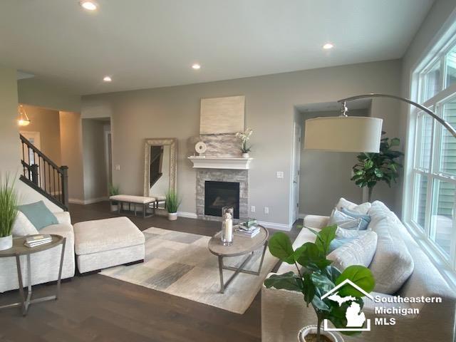 8260 Grande Lake Cir, Temperance, MI 48182 - living room featuring stairs, a stone fireplace, wood finished floors, and recessed lighting