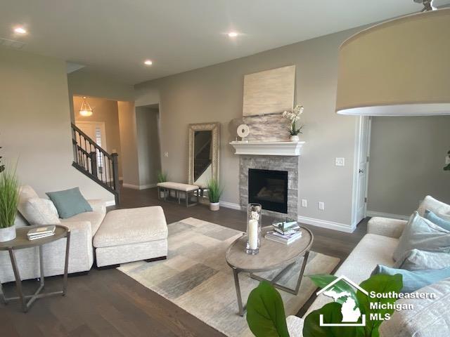 8260 Grande Lake Cir, Temperance, MI 48182 - living room featuring stairs, wood finished floors, a stone fireplace, and recessed lighting