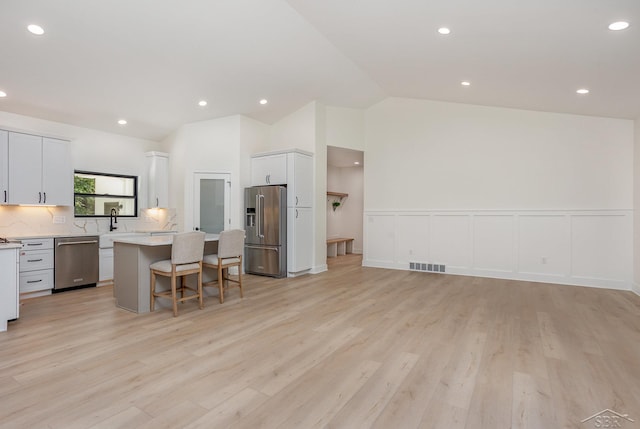 9841 Beech Tree Ln, Frankenmuth, MI 48734 - kitchen with appliances with stainless steel finishes, a center island, a kitchen breakfast bar, light countertops, and open floor plan
