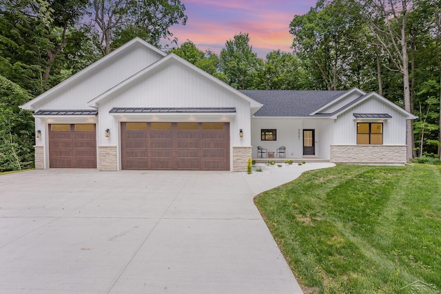 9841 Beech Tree Ln, Frankenmuth, MI 48734 - modern farmhouse style home featuring stone siding, a garage, a standing seam roof, and concrete driveway
