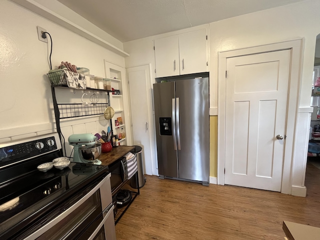 3925 Miramar Ave NE, Grand Rapids, MI 49525 - kitchen with appliances with stainless steel finishes, white cabinets, and wood finished floors