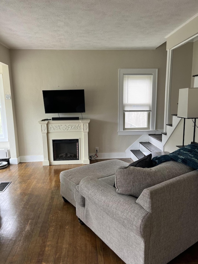 3925 Miramar Ave NE, Grand Rapids, MI 49525 - living area with hardwood / wood-style floors, a fireplace, a textured ceiling, and stairs