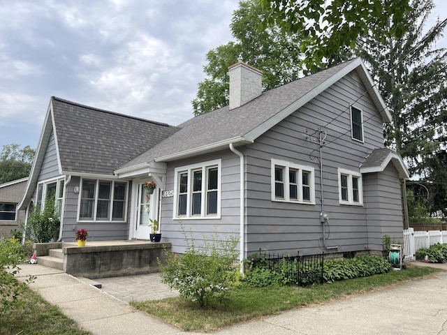 3925 Miramar Ave NE, Grand Rapids, MI 49525 - view of front of house with a chimney and roof with shingles