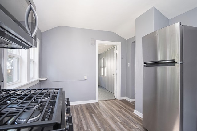 816 Oakhill St SE, Grand Rapids, MI 49507 - kitchen featuring appliances with stainless steel finishes, wood finished floors, and vaulted ceiling