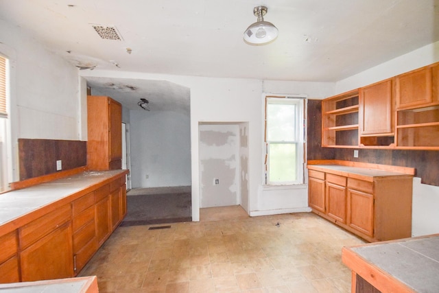 1085 E Chicago Rd Unit A, Quincy, MI 49082 - kitchen featuring open shelves, brown cabinetry, light floors, and light countertops