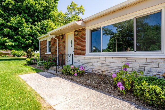 6828 First Ave, Coloma, MI 49038 - doorway to property with stone siding and a lawn
