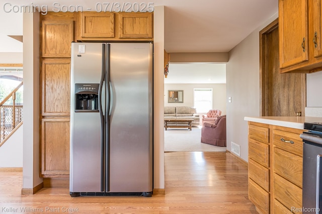 1379 Sioux St, Gladwin, MI 48624 - kitchen featuring stainless steel fridge, light wood-type flooring, brown cabinetry, and light countertops