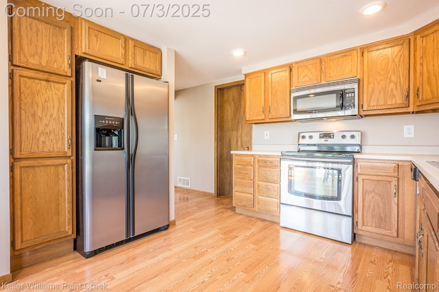 1379 Sioux St, Gladwin, MI 48624 - kitchen with appliances with stainless steel finishes, light wood-style floors, light countertops, recessed lighting, and brown cabinetry