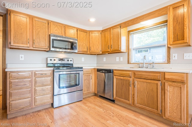 1379 Sioux St, Gladwin, MI 48624 - kitchen featuring appliances with stainless steel finishes, light wood finished floors, light countertops, and brown cabinetry