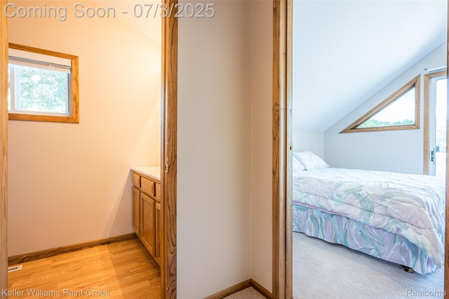 1379 Sioux St, Gladwin, MI 48624 - bedroom featuring multiple windows, vaulted ceiling, and light wood finished floors