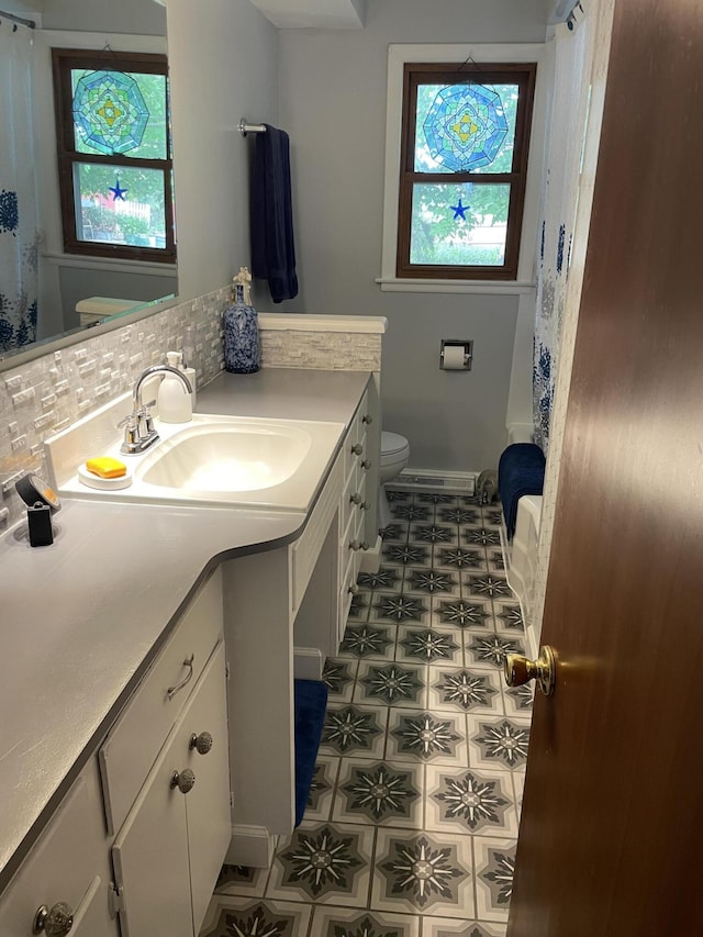 8441 Homerich Ave, Byron Center, MI 49315 - bathroom featuring vanity, decorative backsplash, and tile patterned floors