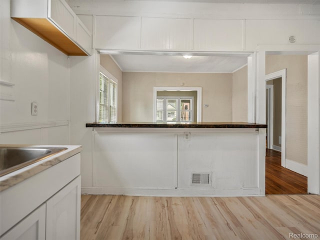 12667 Lauder St, Detroit, MI 48227 - kitchen with light wood-style floors, white cabinetry, and ornamental molding