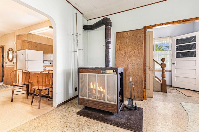 4293 N Schoenherr Rd, Fountain, MI 49410 - detailed view of a wood stove, freestanding refrigerator, tile patterned floors, and arched walkways