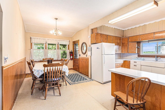 4293 N Schoenherr Rd, Fountain, MI 49410 - kitchen featuring freestanding refrigerator, brown cabinetry, wainscoting, light countertops, and healthy amount of natural light