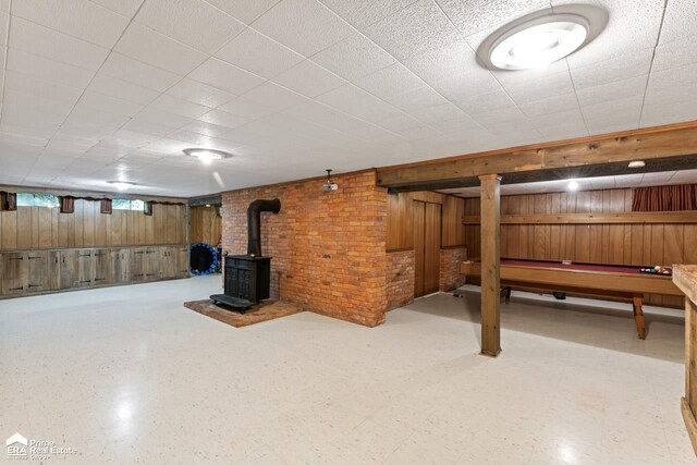 6494 W Coldwater Rd, Flushing, MI 48433 - basement with wood walls, a wood stove, brick wall, tile patterned floors, and pool table