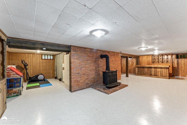 6494 W Coldwater Rd, Flushing, MI 48433 - basement featuring wood walls, a wood stove, and a bar