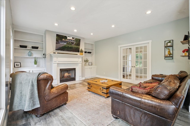 7987 36th St SE, Ada, MI 49301 - living area featuring wood finished floors, recessed lighting, a fireplace with flush hearth, french doors, and built in shelves