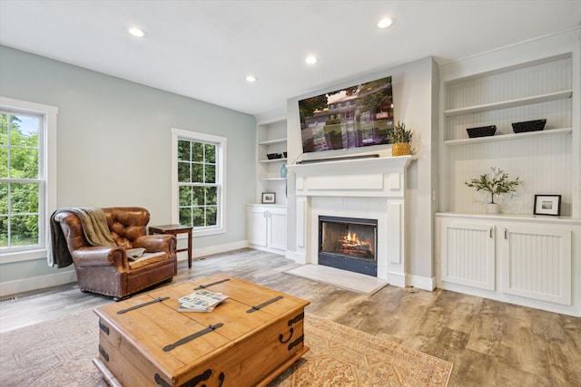 7987 36th St SE, Ada, MI 49301 - living room with light wood-style flooring, a tile fireplace, recessed lighting, and built in shelves