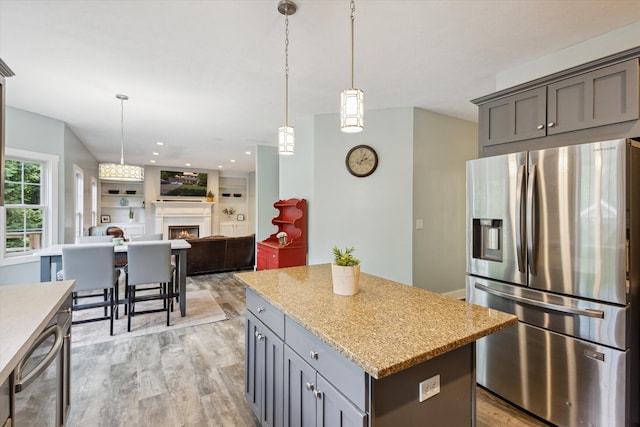7987 36th St SE, Ada, MI 49301 - kitchen with stainless steel appliances, a kitchen island, light wood finished floors, pendant lighting, and gray cabinetry