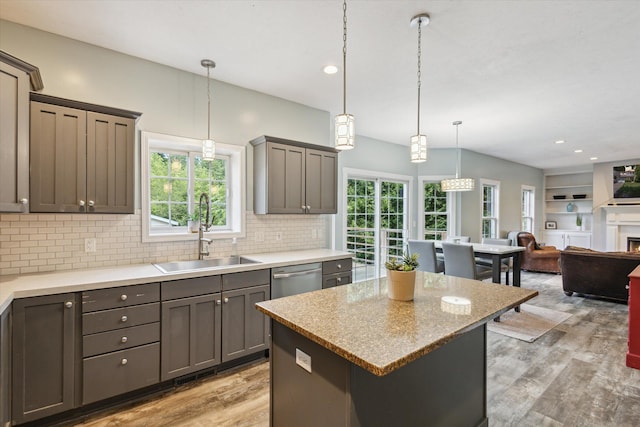 7987 36th St SE, Ada, MI 49301 - kitchen featuring light wood-style flooring, decorative backsplash, dishwasher, open floor plan, and a kitchen island