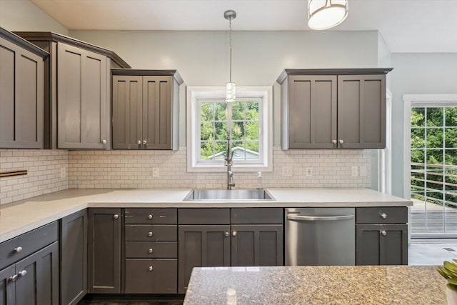7987 36th St SE, Ada, MI 49301 - kitchen featuring stainless steel dishwasher, decorative backsplash, hanging light fixtures, and light countertops