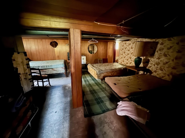 4231 W 5 Mile Rd, Irons, MI 49644 - bedroom with unfinished concrete floors and wooden walls