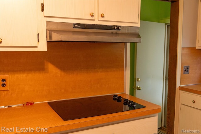 25640 Grand Concourse St, Southfield, MI 48075 - kitchen featuring under cabinet range hood, black electric stovetop, and light countertops