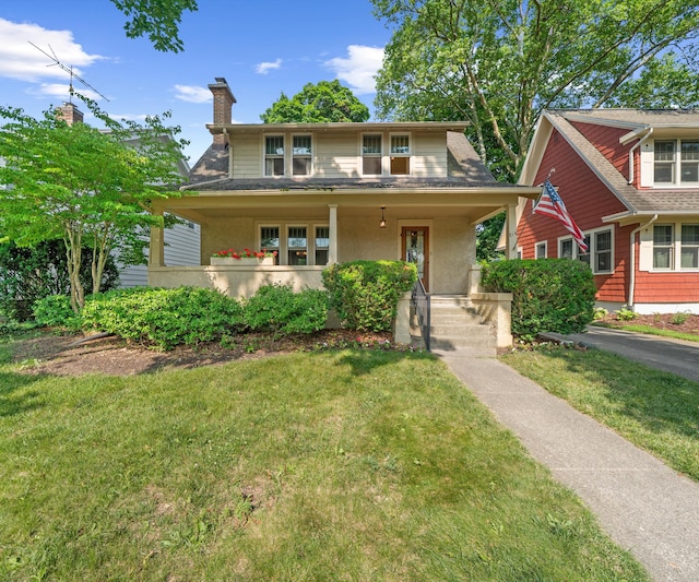 216 Kenwood Ave, Ann Arbor, MI 48103 - bungalow with a front yard, covered porch, a chimney, and stucco siding