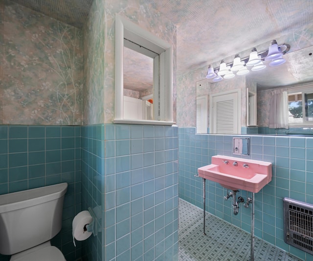 216 Kenwood Ave, Ann Arbor, MI 48103 - bathroom with tile walls, wallpapered walls, a wainscoted wall, heating unit, and walk in shower