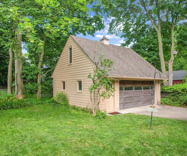 216 Kenwood Ave, Ann Arbor, MI 48103 - view of home's exterior with a chimney, a yard, roof with shingles, and a detached garage