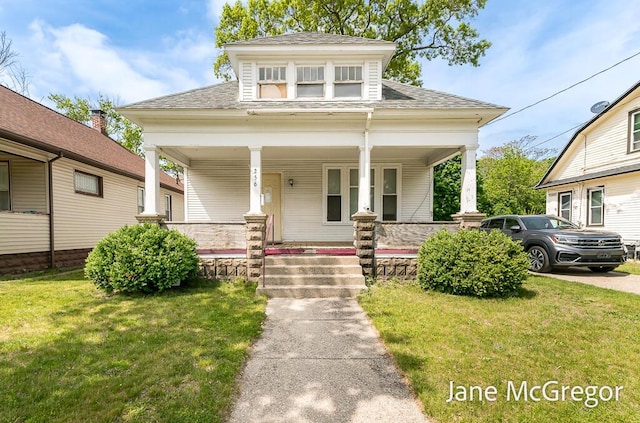 256 W Forest Ave, Muskegon, MI 49441 - view of front of property featuring covered porch, roof with shingles, and a front lawn