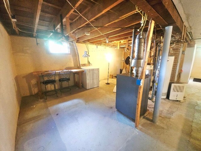 1308 W Broadway, Mount Pleasant, MI 48858 - below grade area featuring water heater, washing machine and clothes dryer, and a heating unit
