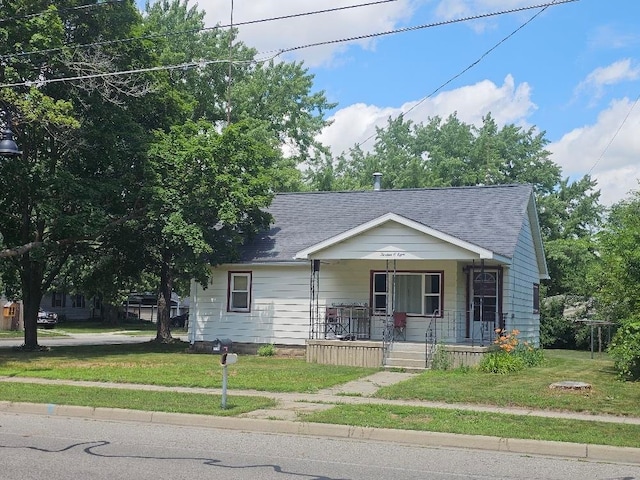 1308 W Broadway, Mount Pleasant, MI 48858 - bungalow featuring a porch, a front lawn, and roof with shingles