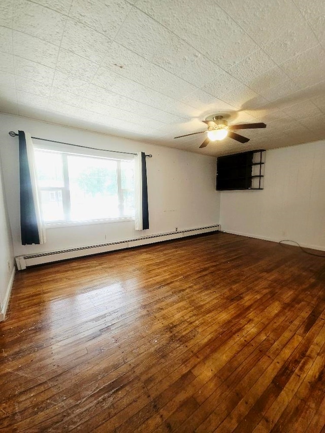1308 W Broadway, Mount Pleasant, MI 48858 - spare room with a baseboard heating unit, a ceiling fan, and hardwood / wood-style flooring