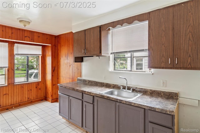 5981 University Pl, Detroit, MI 48224 - kitchen with dark countertops, healthy amount of natural light, wood walls, and gray cabinets