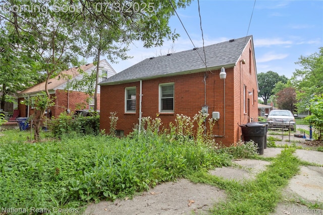 5981 University Pl, Detroit, MI 48224 - view of side of property featuring a shingled roof and brick siding