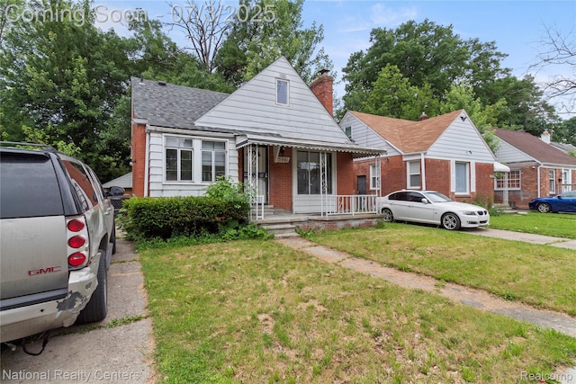 5981 University Pl, Detroit, MI 48224 - bungalow with brick siding, a front yard, a chimney, roof with shingles, and covered porch