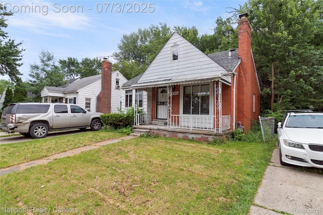 5981 University Pl, Detroit, MI 48224 - view of front of house with a porch, a front lawn, and brick siding