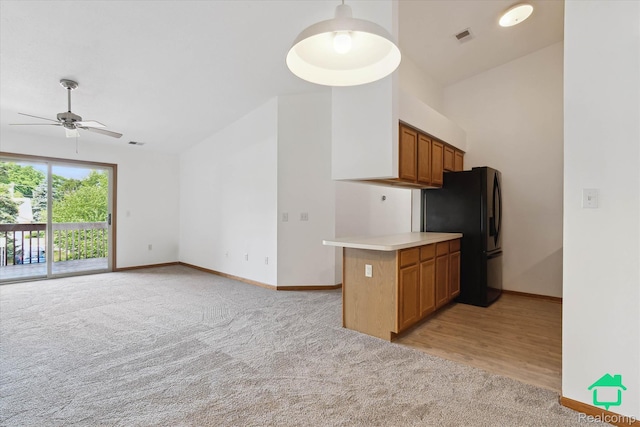 45833 Wildrye Ct, Van Buren, MI 48111 - kitchen with freestanding refrigerator, light carpet, brown cabinetry, a ceiling fan, and light countertops