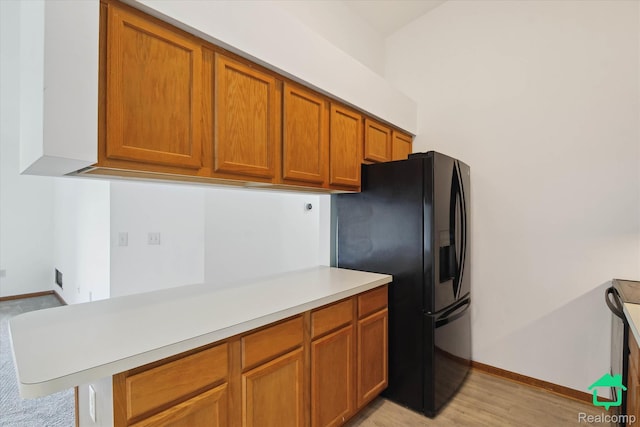 45833 Wildrye Ct, Van Buren, MI 48111 - kitchen with black fridge with ice dispenser, brown cabinets, light countertops, and light wood-type flooring