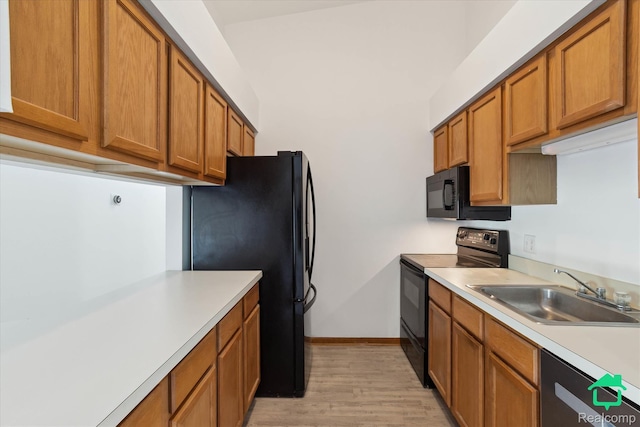 45833 Wildrye Ct, Van Buren, MI 48111 - kitchen featuring black appliances, light countertops, brown cabinetry, and light wood-style floors
