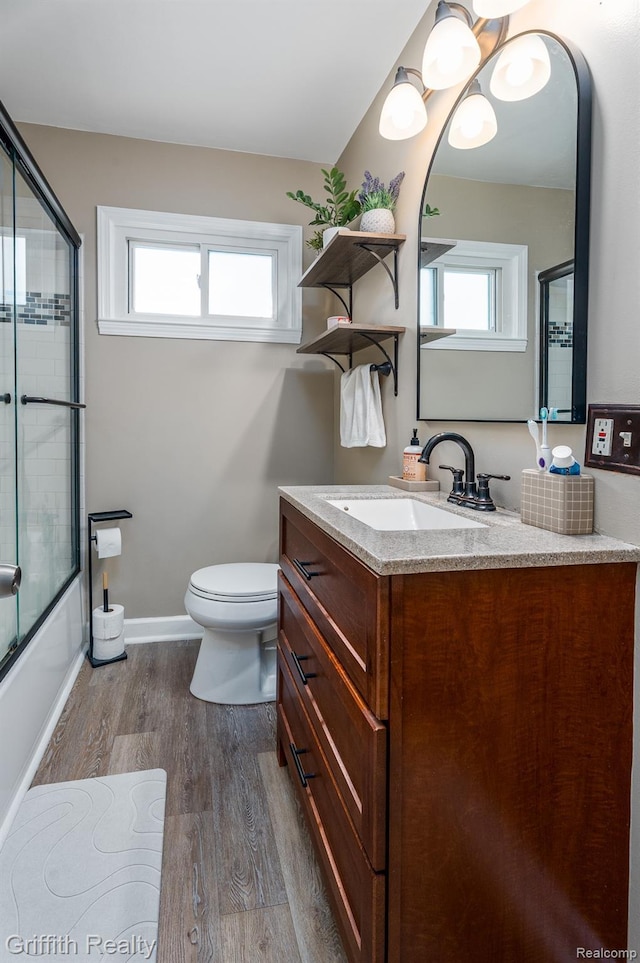 2001 Brockton Ave, Royal Oak, MI 48067 - full bathroom featuring wood finished floors, vanity, and bath / shower combo with glass door