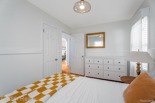 2001 Brockton Ave, Royal Oak, MI 48067 - bedroom featuring multiple windows, a wainscoted wall, and wood finished floors