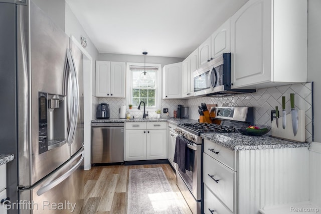 2001 Brockton Ave, Royal Oak, MI 48067 - kitchen with stainless steel appliances, light wood-style flooring, light stone counters, and white cabinetry