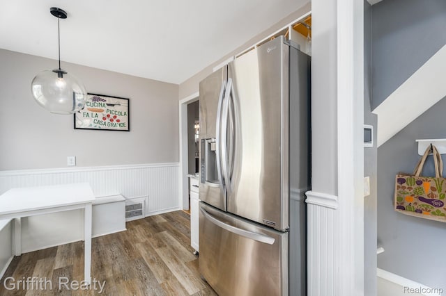 2001 Brockton Ave, Royal Oak, MI 48067 - kitchen featuring stainless steel refrigerator with ice dispenser, wood finished floors, a wainscoted wall, and decorative light fixtures