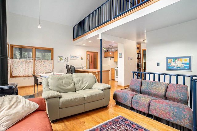 9191 W Ranger Rd, Mears, MI 49436 - living area featuring a towering ceiling, wood finished floors, and a wood stove